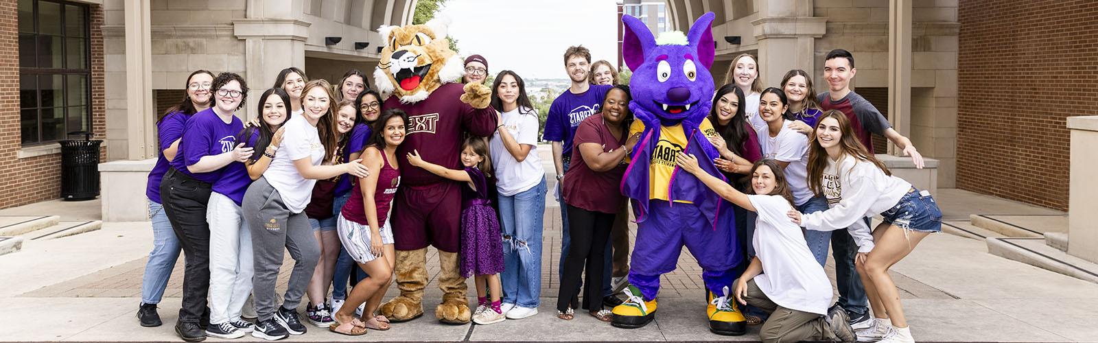 Texas State University and ACC students pose together on Texas State's campus.